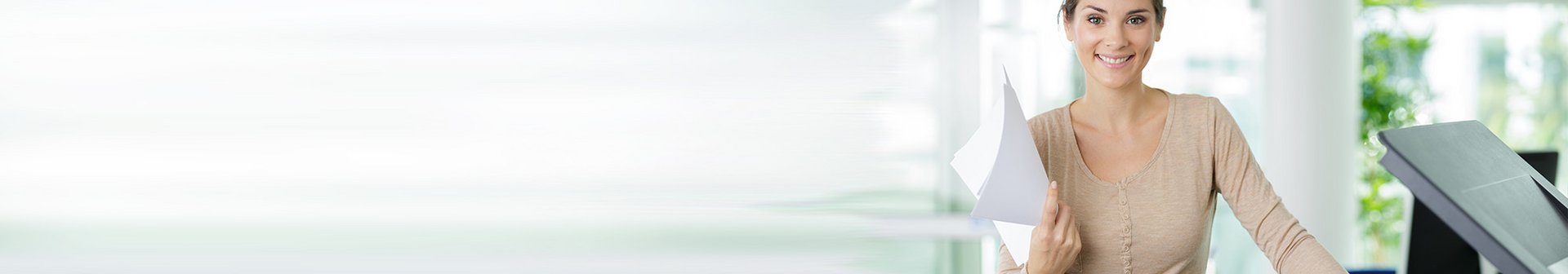 Image Banner Support Frau steht lächelnd neben einem Kopierer