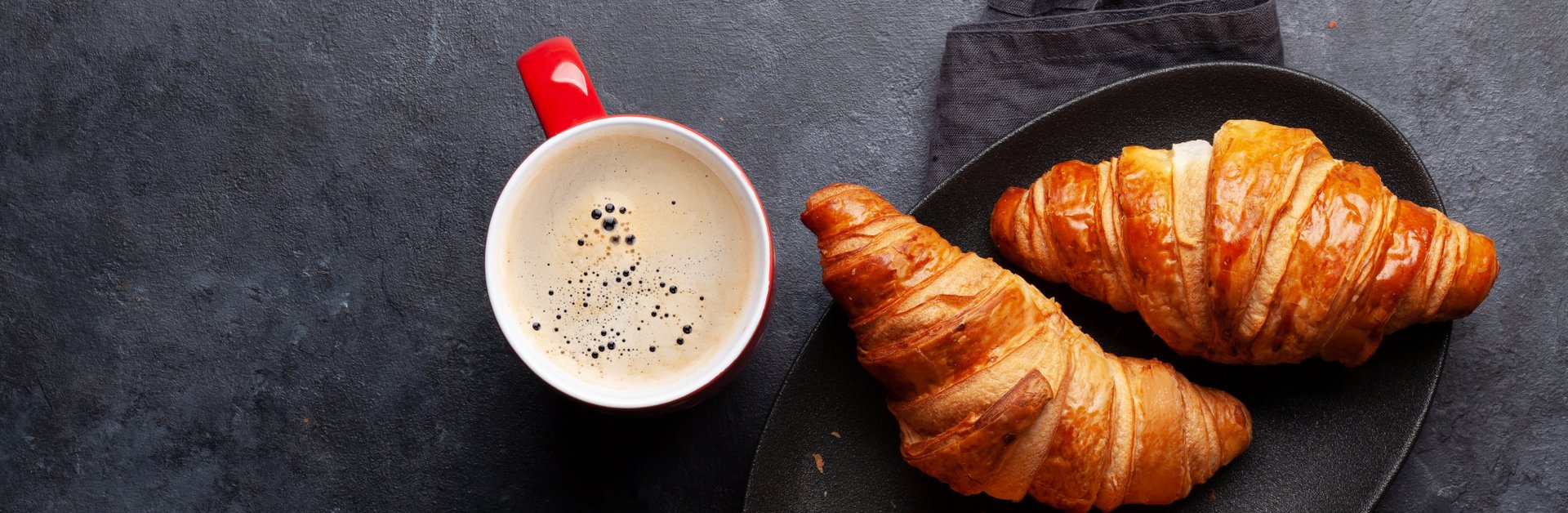 Tasse mit Croissants auf Tisch